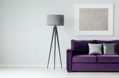 Grey lamp, purple sofa and modern painting on the wall set in a living room interior